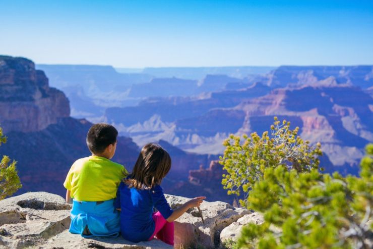 Boy and girl sitting near canyon