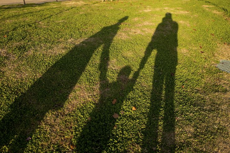 Shadow of child holding hands with parents