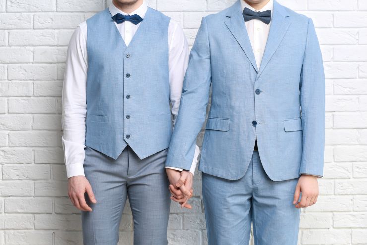 Two men in suits holding hands