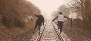 Couple balancing on train tracks