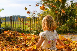 child playing in leaves