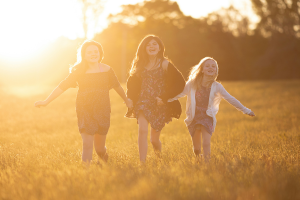 Three girls running in the field