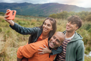 Teenagers taking selfie with dad outdoors