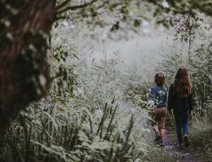 Boy and girl walking on path in long grass