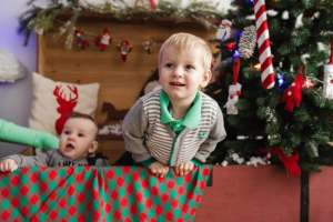 Two children in box with Christmas tree