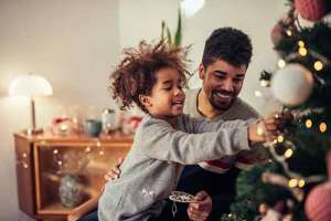 Man and child decorating christmas tree