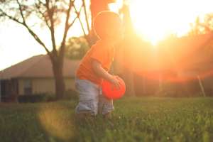 Little boy holding an orange ball